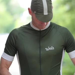 Man wearing matching green walz jersey and cycling cap.