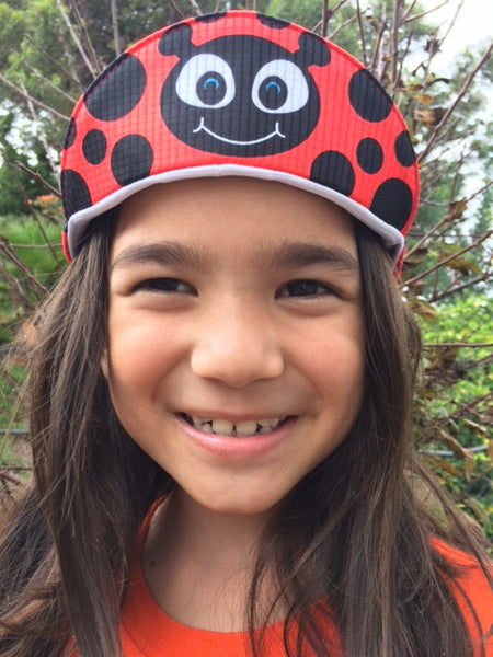 Girl wearing the lexi the ladybug cap.