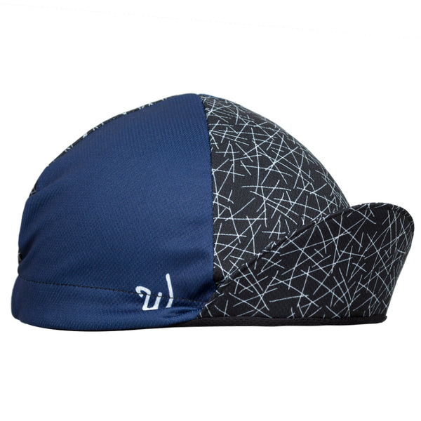 "Dart" Technical 4-Panel Cap.  Navy blue cap with black and white cross-stitch print.  Angled View. Bill up.