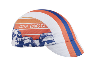 South Dakota Technical 3-Panel Cycling Cap. White and orange cap with blue and orange stripes.  SOUTH DAKOTA text and Mount Rushmore imagery on side.  Angled view.