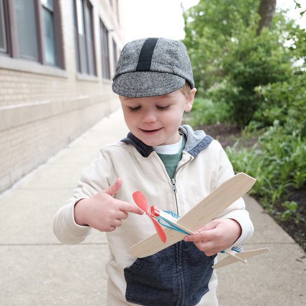 Child wearing the Buckaroo kids cap and playing with a toy airplane.