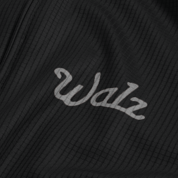 Close-up of gray Walz logo on black fabric.