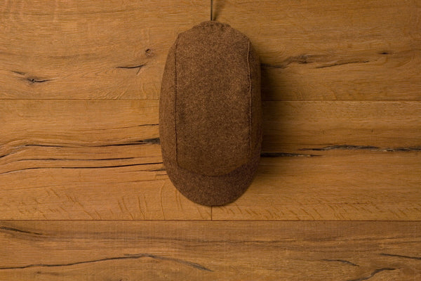 Velo/City Cap - Brown Tweed Wool lying on a table. Overhead view.