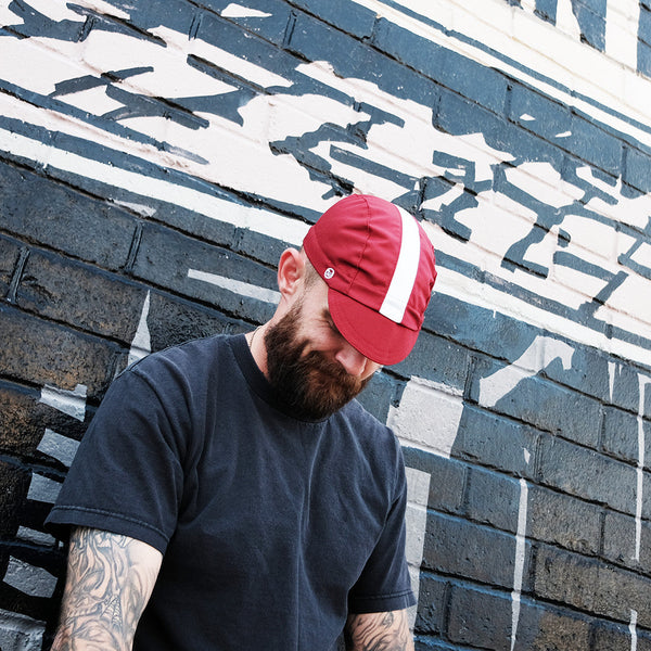 Man wearing collegiate fast cap looking down.