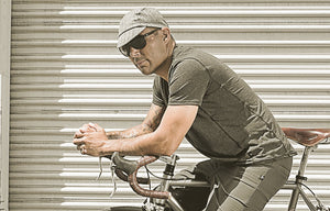 Man leaning forward on a bike wearing sunglasses and a walz cap.  Text: Modern Fit. Classic Style.