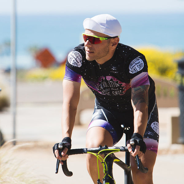 Man on bike wearing the white technical 4-panel cap with brim up.