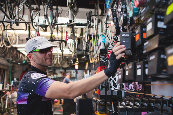 Man shopping in a bike shop wearing the velo/city grey cotton cap.