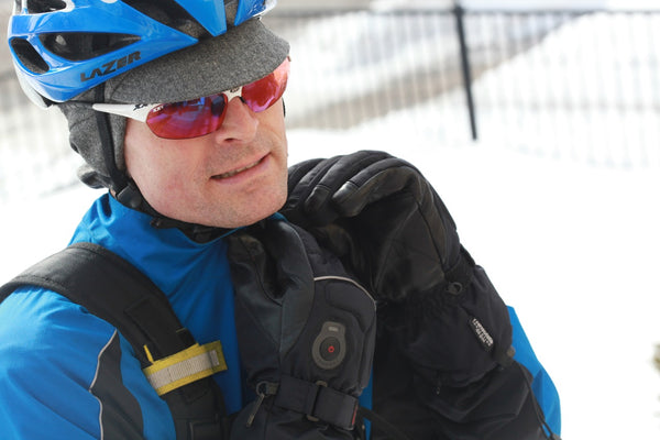 Man wearing an ear flap cap under a helmet in the winter.