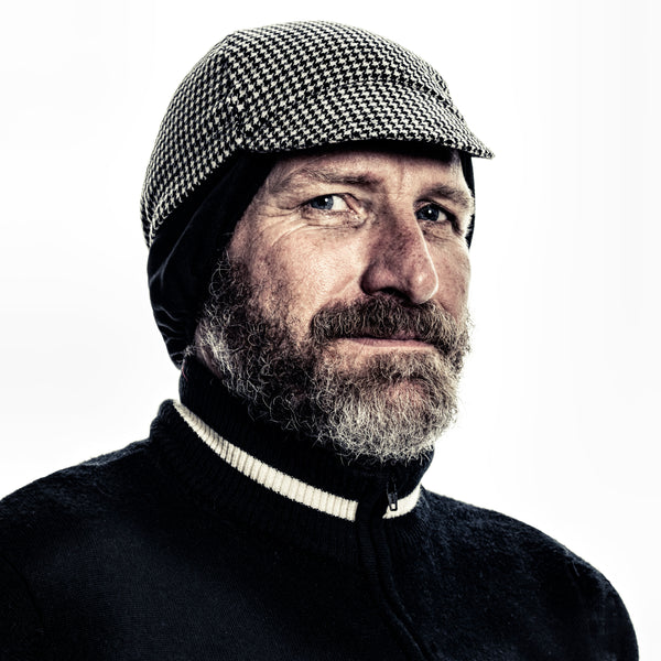 Bearded man wearing houndstooth wool ear flap cap.