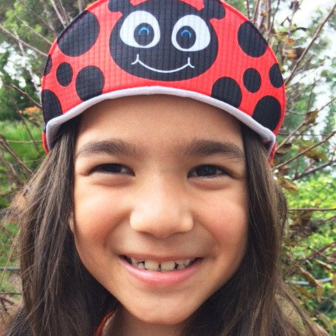 Girl wearing the lexi the ladybug cap.
