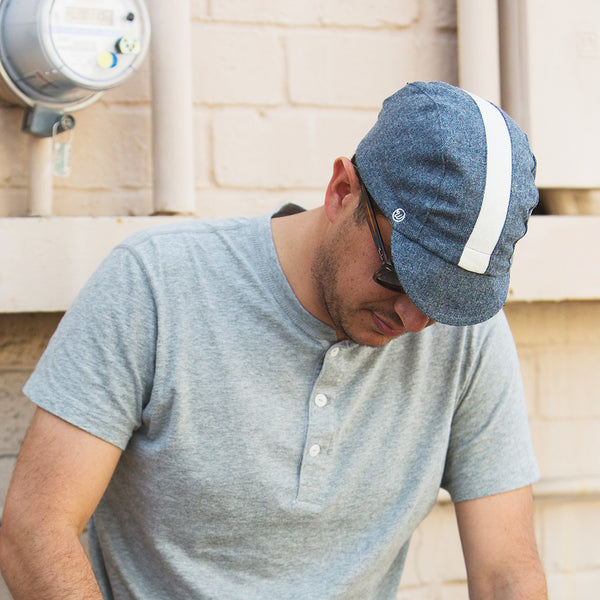 Man wearing blue cadet wool cap looking down.