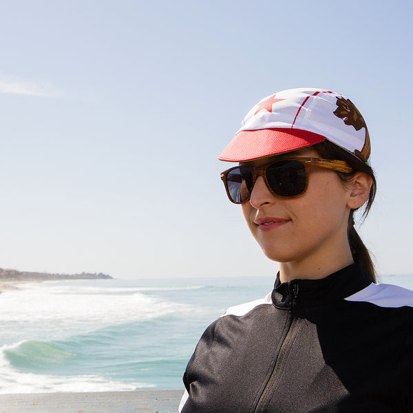 Woman with sunglasses at the beach wearing the California technical cap.