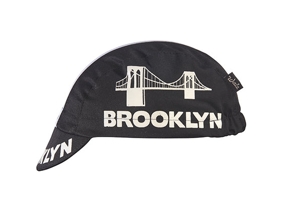 Brooklyn Black Cotton 3-Panel Cycling Cap.  White stripe with Brooklyn bridge logo and Brooklyn text on side and brim.  Side view.