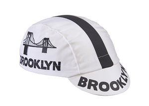 Brooklyn White Cotton 3-Panel Cycling Cap with Black Stripe.  Brooklyn bridge logo and Brooklyn text on side and brim. Angled view.