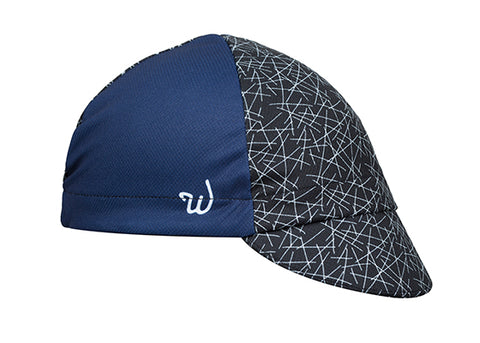 "Dart" Technical 4-Panel Cap.  Navy blue cap with black and white cross-stitch print.  Angled View.